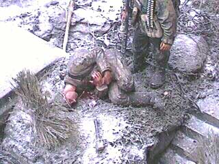 A dead Russian lays at the feet of a Grenadier with Vampir gear gripping a chest wound. The Russian is from the Tamiya "Russian Infantry" set with hands from the scrap box. His panzerfaust has been propped against a rock, whilst his PPSh-41 machine gun has been shouldered by the German